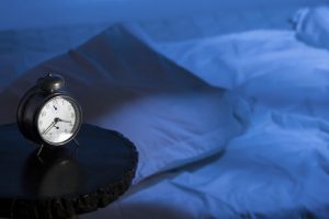 Alarm clock with empty bed and moon-light effect.