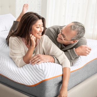 Man and woman laying on a Tempur-Pedic mattress