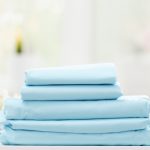 Stack of folded fitted sheets, flat sheets, and pillowcases