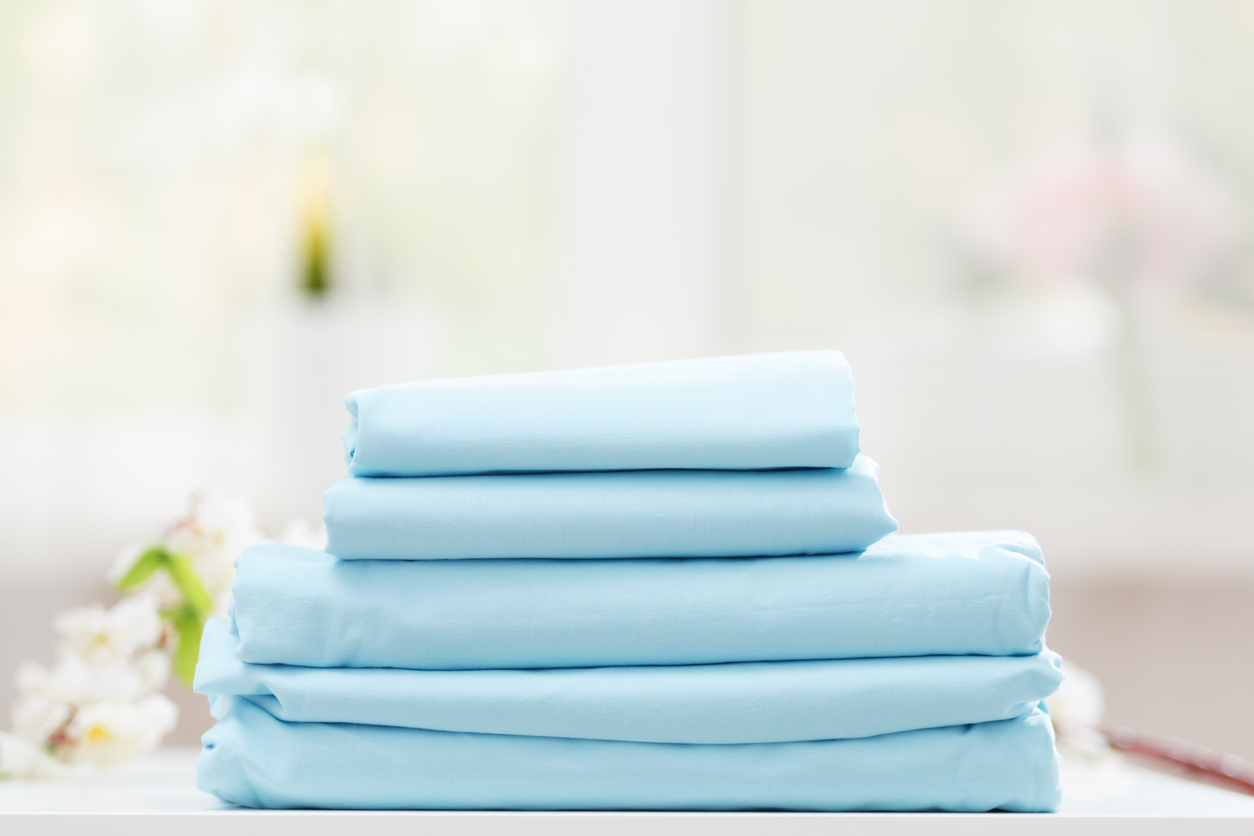 Stack of folded fitted sheets, flat sheets, and pillowcases