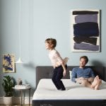 Girl jumping on queen bed dad laying back watching