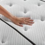 Woman's hand feeling a plush mattress top