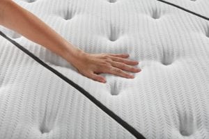 Woman's hand feeling a plush mattress top
