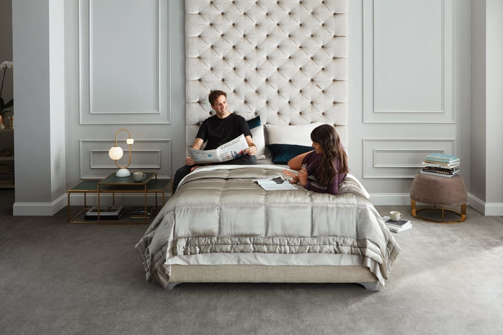 Couple sitting on a luxury mattress reading comfortably