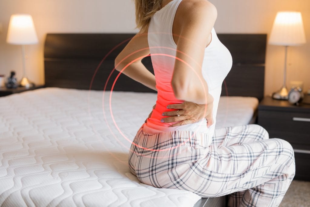 Female suffering from back pain because of uncomfortable mattress