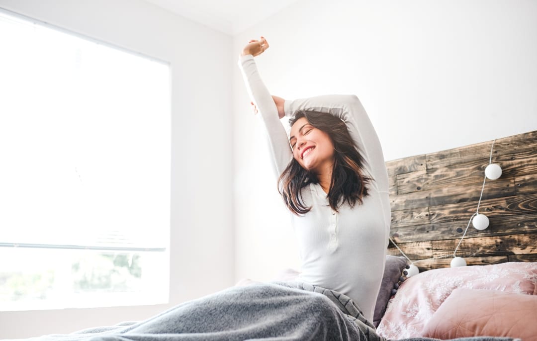 Woman stretching after best night's sleep