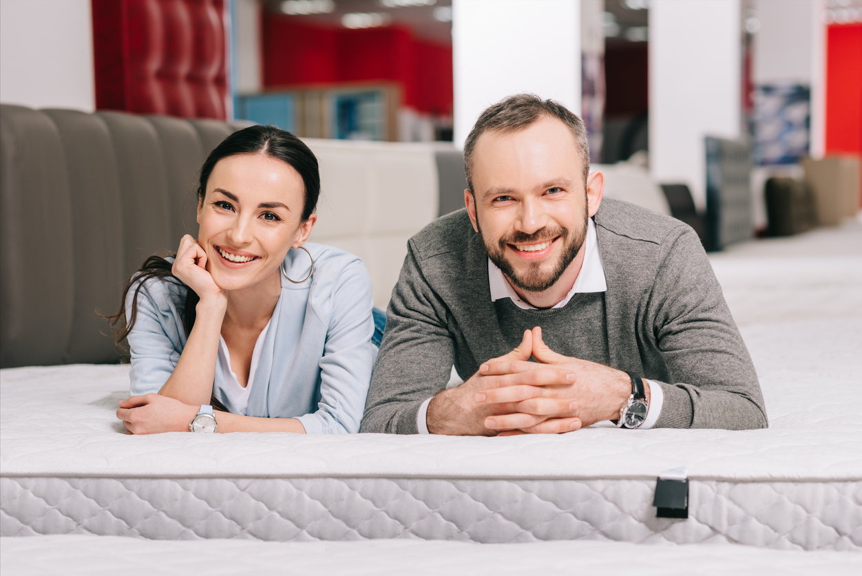 Couple laying on mattress in a store