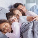 Family sleeping soundly in bed