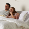 Man and woman laying in purple adjustable bed with head raised