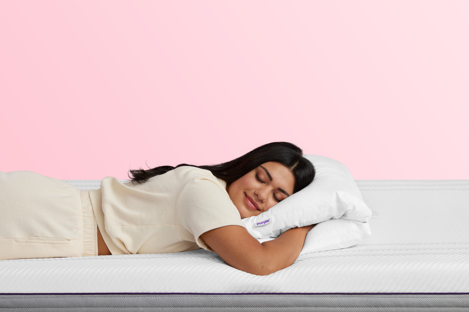 Woman sleeping with hand tucked in The Purple TwinCloudTM Pillow