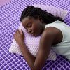 Woman sleeping on a Purple Harmony™ Pillow and GelFlex Grid mattress