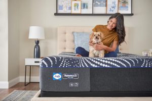 Sealy Posturepedic Hybrid Plus mattress with woman and dog