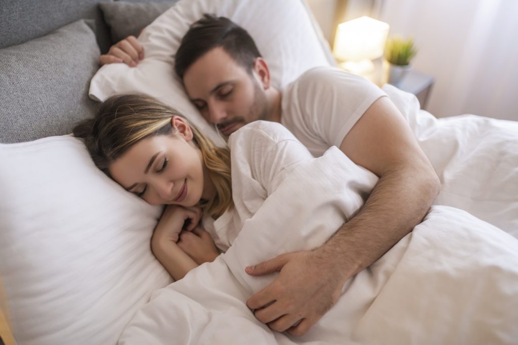 Couple sleeping comfortably in bed