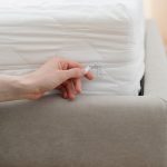 Woman storing a mattress with a mattress cover